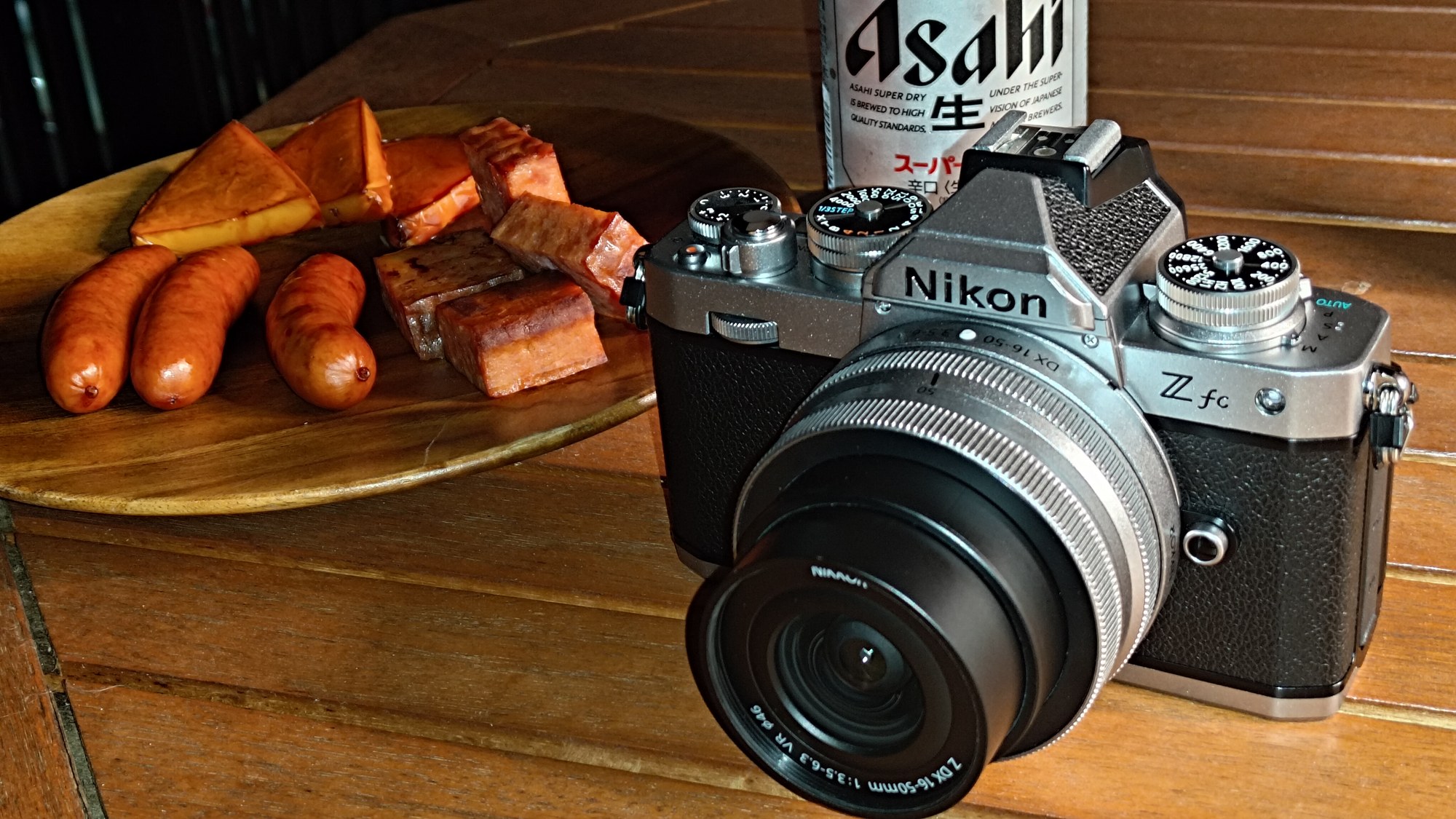 皿と缶の手前に置いたNikon Z fc。上面のダイヤルとISOダイヤル下のモードレバー