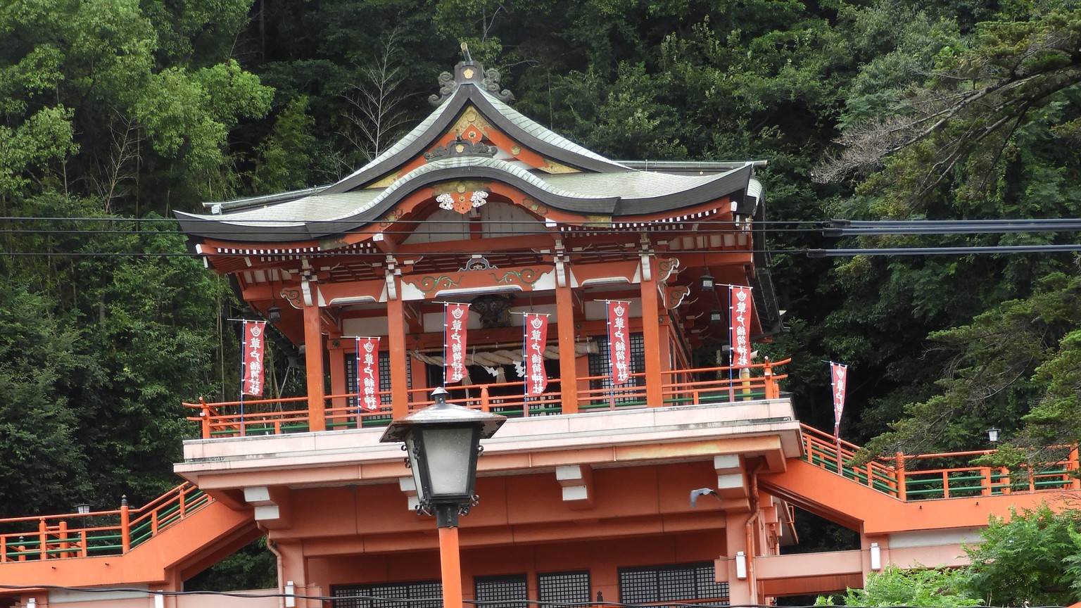 緑の山を背にした草戸稲荷神社の朱色の社殿