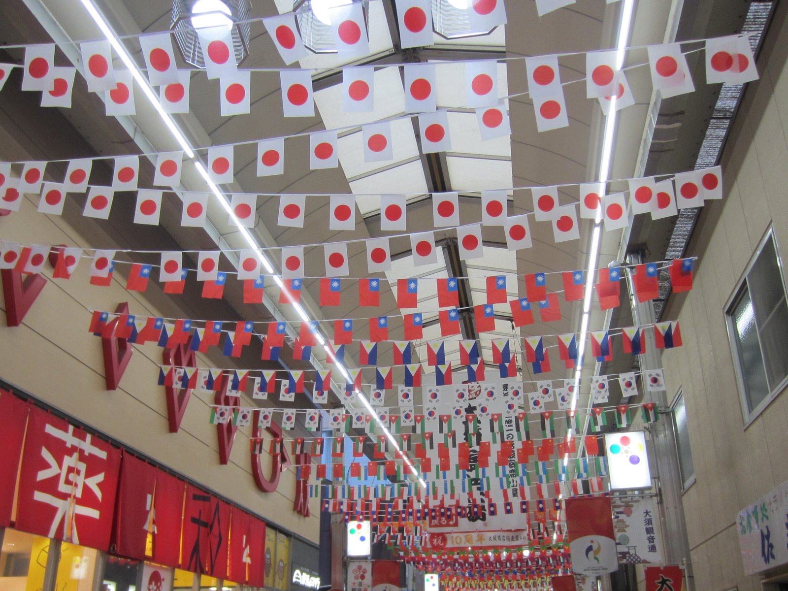 大須観音通りのアーケードの天井いっぱいに、日本や外国の国旗が連なって下がっている商店街の様子