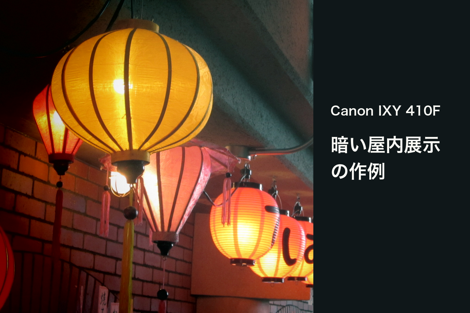 Canon IXY 410Fで撮った黄色と赤い提灯の実写に、機種名と暗い屋内展示の作例という文字を添えたアイキャッチ