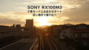 SONY RX100M3で西条駅の構内から撮影した、線路の先に沈む夕日。写真の上に「SONY RX100M3」「夕景モードとおまかせオート」「同じ場所で撮り比べ」の文字を重ねたアイキャッチ